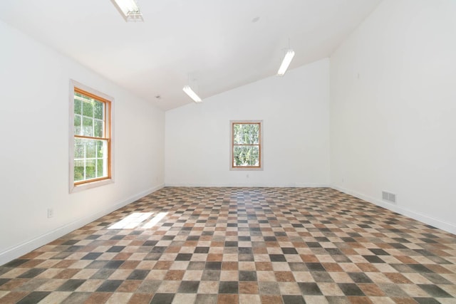 spare room featuring lofted ceiling, visible vents, and baseboards