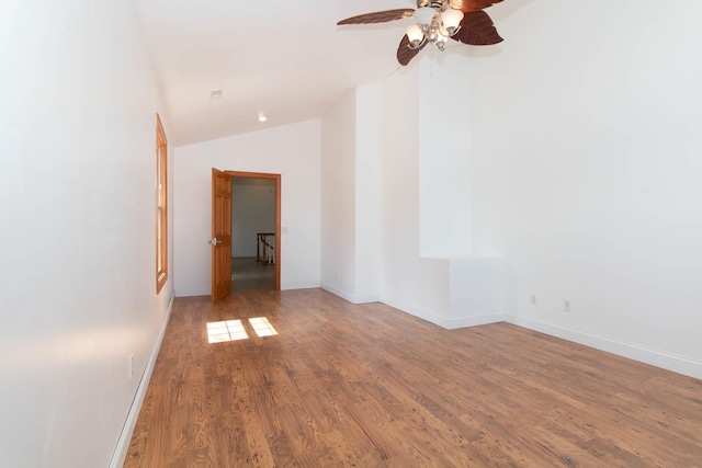 unfurnished room featuring lofted ceiling, wood finished floors, baseboards, and ceiling fan