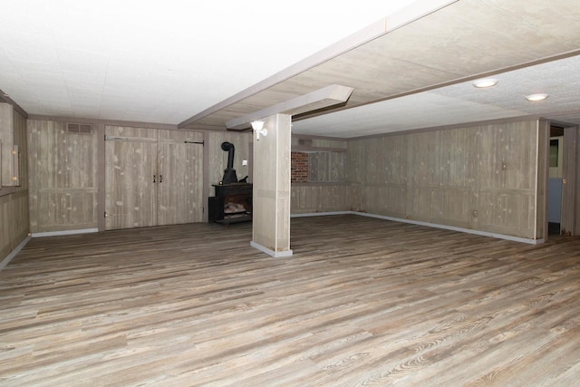 finished below grade area with wood walls, a wood stove, and wood finished floors