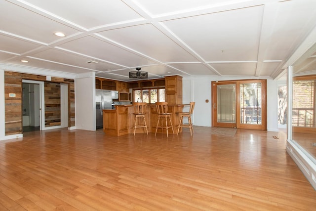 living area featuring bar area, coffered ceiling, and light wood-type flooring
