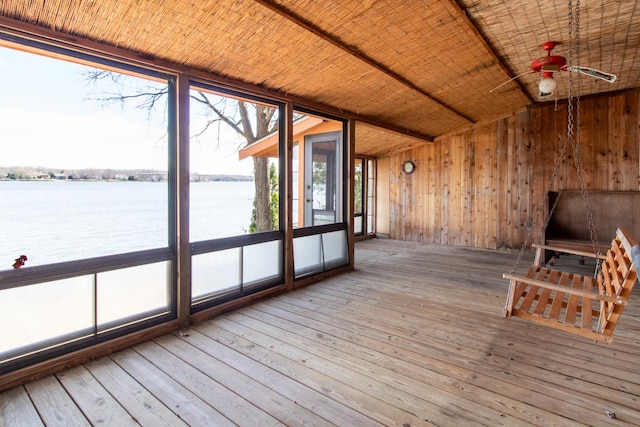 unfurnished sunroom featuring a water view