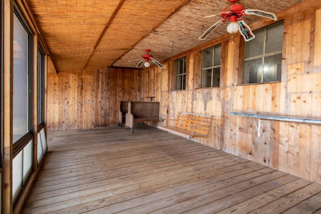 spare room with a ceiling fan, wood walls, and hardwood / wood-style flooring