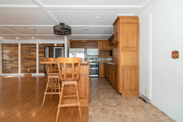 kitchen with recessed lighting, brown cabinets, and appliances with stainless steel finishes