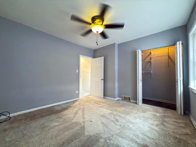 unfurnished bedroom featuring visible vents, baseboards, a closet, a ceiling fan, and carpet floors