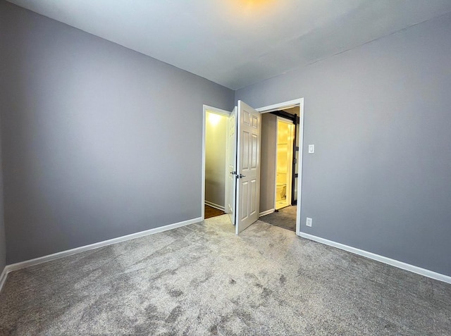unfurnished bedroom featuring carpet flooring and baseboards