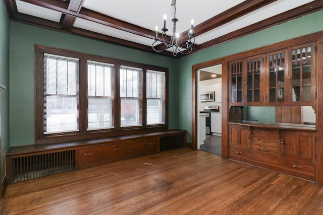 unfurnished dining area with a chandelier, dark wood-type flooring, radiator heating unit, and beamed ceiling