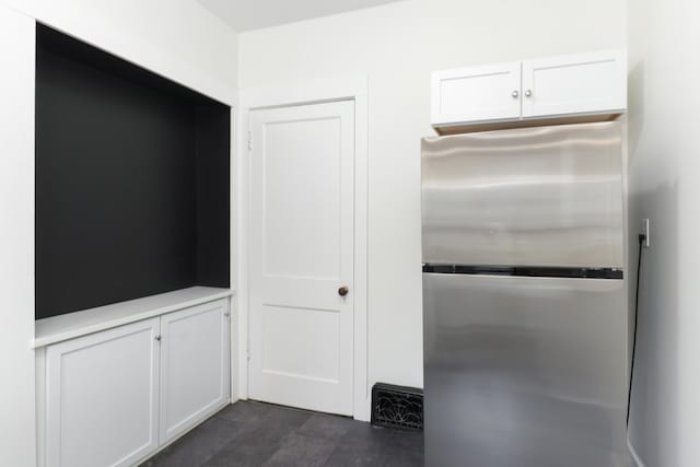 room details with light countertops, white cabinets, and freestanding refrigerator