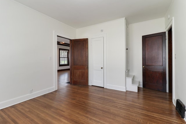 unfurnished bedroom with crown molding, wood finished floors, and baseboards