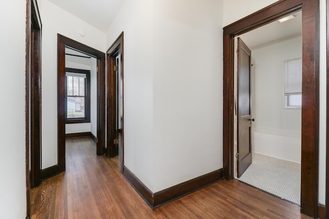 hall featuring baseboards and wood finished floors