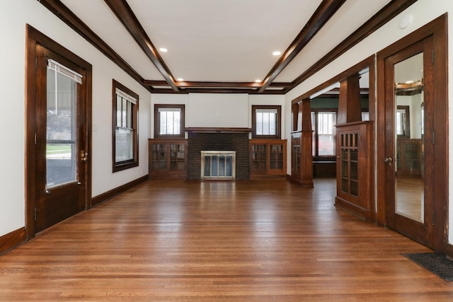 unfurnished living room featuring visible vents, a fireplace, beam ceiling, recessed lighting, and wood finished floors