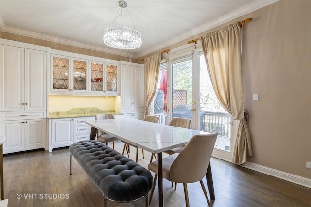 dining area featuring a chandelier, dark wood-type flooring, baseboards, and crown molding