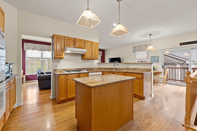 803 Pleasant Dr, Fox River Grove, IL 60021 - kitchen with light wood finished floors, under cabinet range hood, a center island, light stone counters, and white appliances