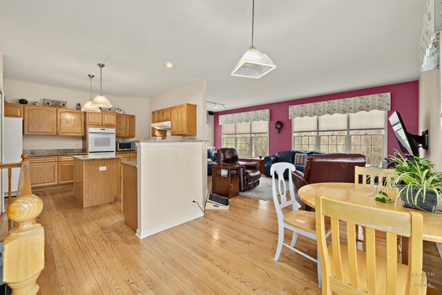 803 Pleasant Dr, Fox River Grove, IL 60021 - kitchen with light wood-style floors, under cabinet range hood, a center island, white appliances, and hanging light fixtures