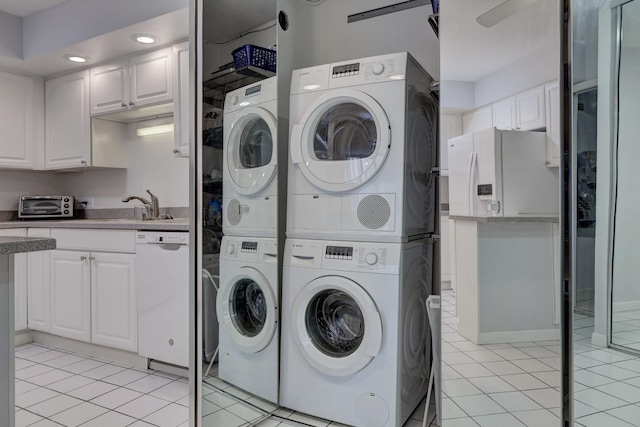 laundry area with washing machine and dryer, stacked washer / drying machine, laundry area, and light tile patterned flooring
