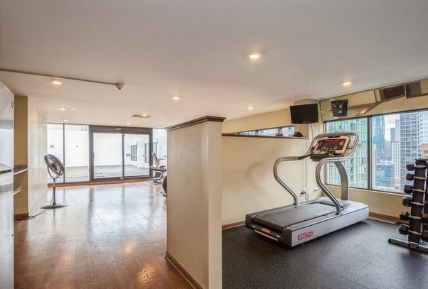 workout room featuring wood finished floors, baseboards, and recessed lighting