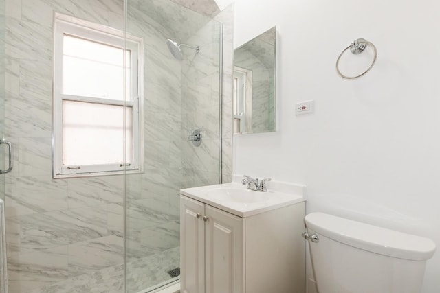 bathroom featuring toilet, vanity, and a marble finish shower