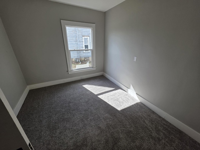 unfurnished room with baseboards and carpet floors