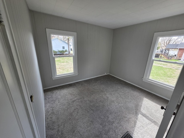 carpeted empty room featuring baseboards