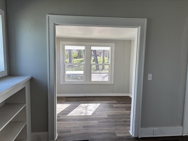 doorway with wood finished floors and baseboards