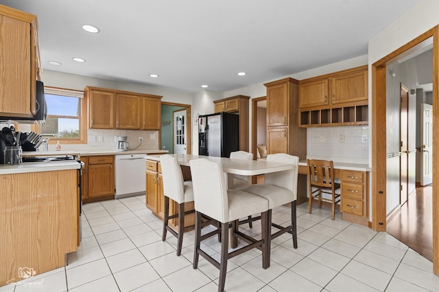 kitchen with light tile patterned floors, dishwasher, light countertops, and refrigerator with ice dispenser