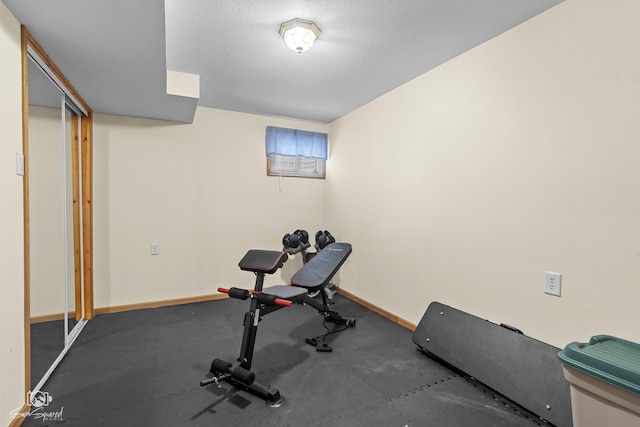 workout room with a textured ceiling and baseboards