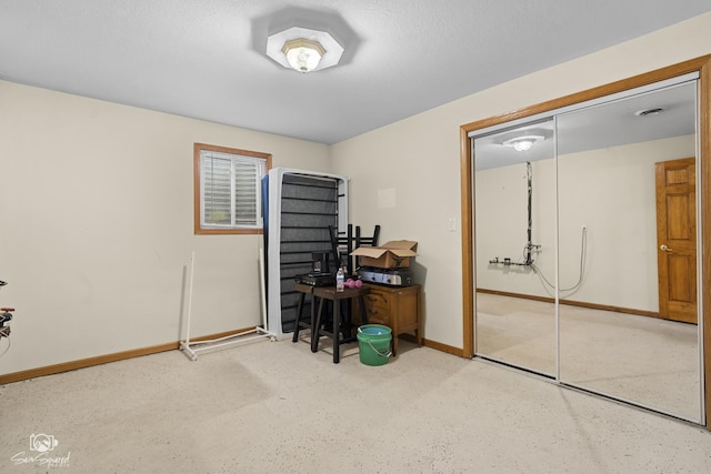 bedroom with a closet, baseboards, and a textured ceiling
