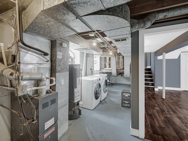 basement featuring water heater, stairway, visible vents, and separate washer and dryer
