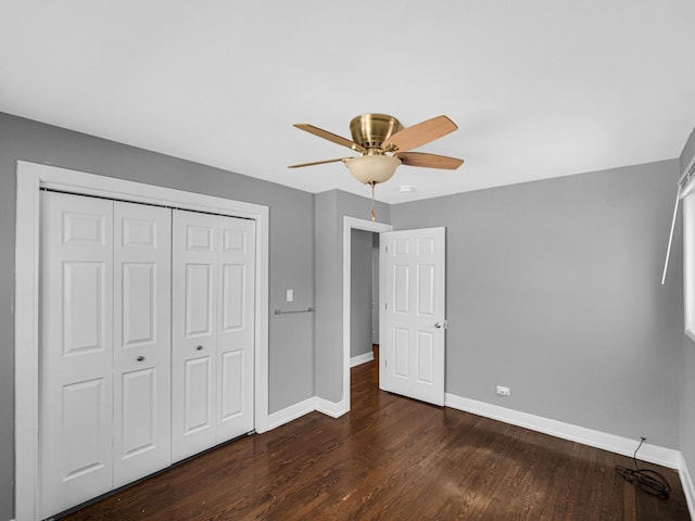 unfurnished bedroom featuring wood finished floors, a closet, a ceiling fan, and baseboards