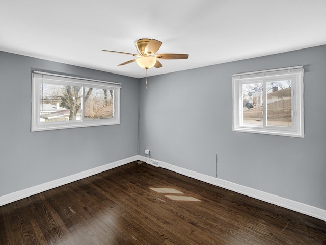 unfurnished room with ceiling fan, baseboards, and dark wood-style floors