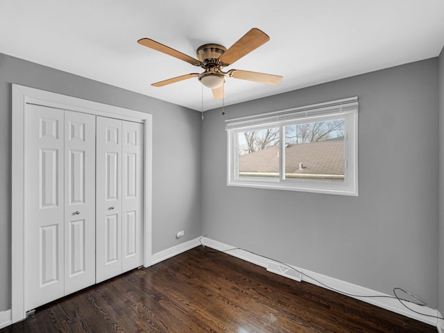 unfurnished bedroom featuring visible vents, baseboards, a closet, ceiling fan, and dark wood-type flooring