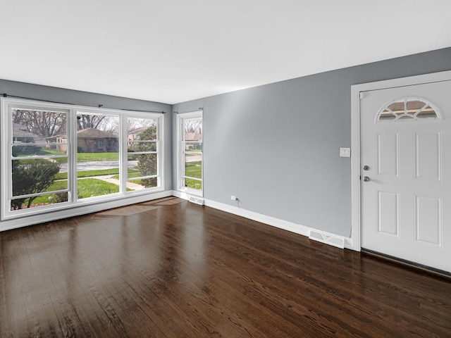 interior space with wood finished floors, visible vents, and baseboards
