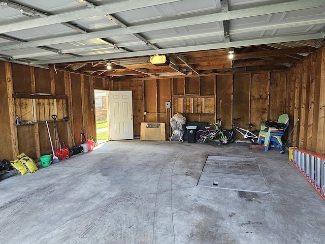 garage with a garage door opener and wood walls