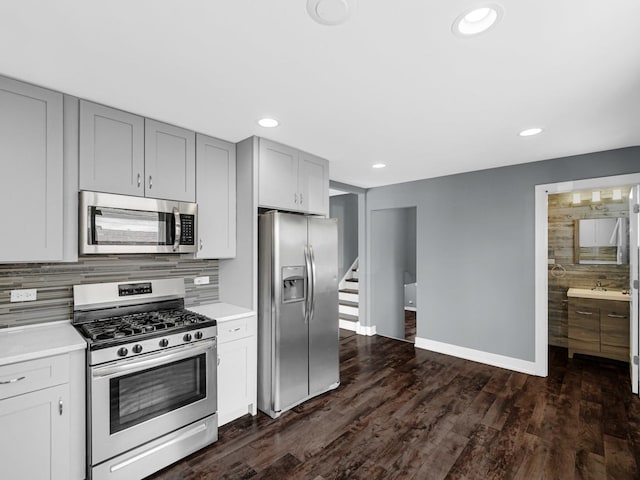 kitchen with stainless steel appliances, light countertops, baseboards, and decorative backsplash