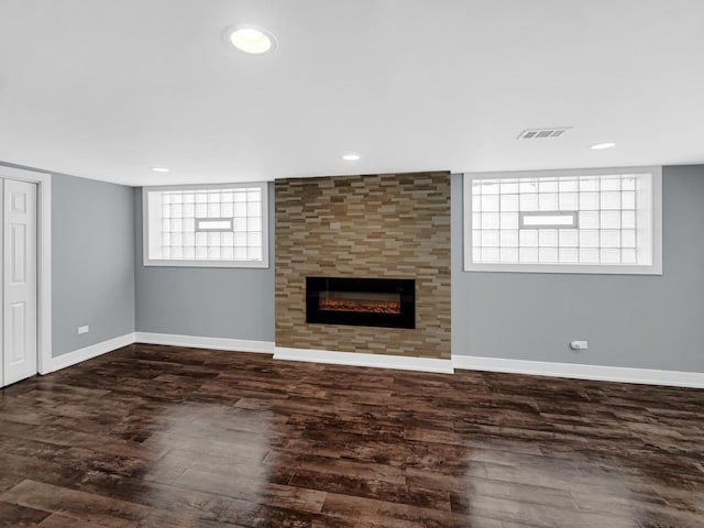 unfurnished living room with baseboards, visible vents, recessed lighting, wood finished floors, and a tile fireplace