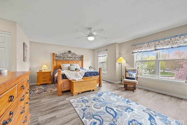 bedroom with light wood-style floors, baseboards, and a ceiling fan