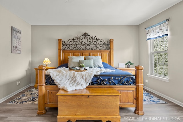 bedroom featuring wood finished floors and baseboards