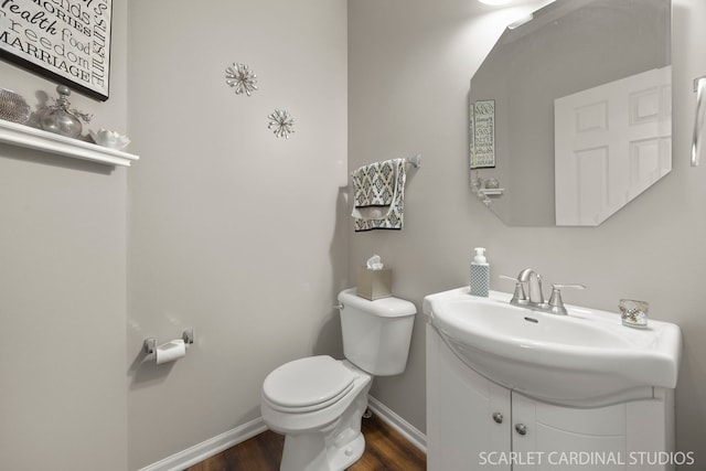 bathroom featuring toilet, wood finished floors, baseboards, and vanity