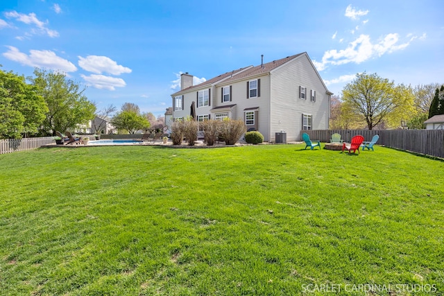 rear view of house with a chimney, an outdoor fire pit, and central air condition unit