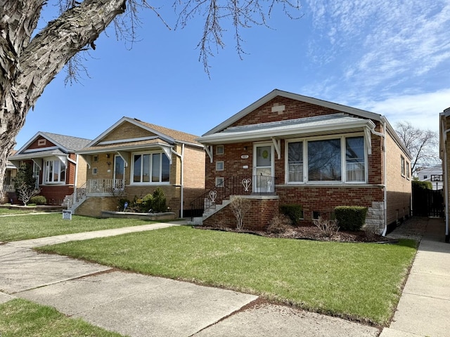 bungalow with brick siding and a front lawn