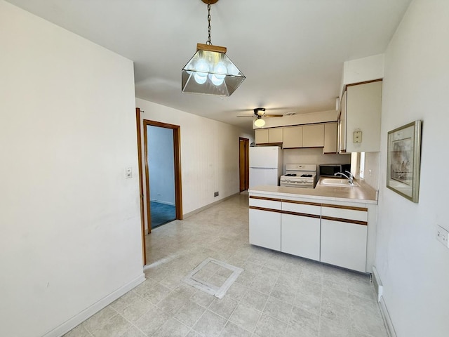 kitchen with a sink, light countertops, a ceiling fan, white appliances, and a peninsula
