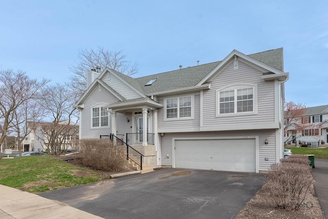 raised ranch featuring roof with shingles, driveway, a chimney, and an attached garage