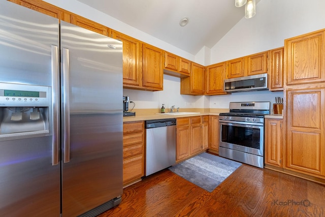 kitchen featuring high vaulted ceiling, dark wood-style floors, light countertops, stainless steel appliances, and a sink