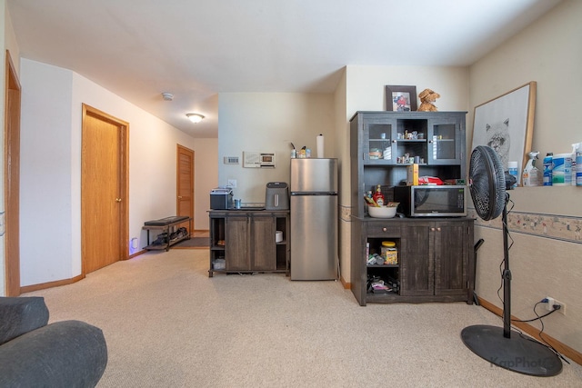 kitchen featuring light colored carpet and stainless steel appliances