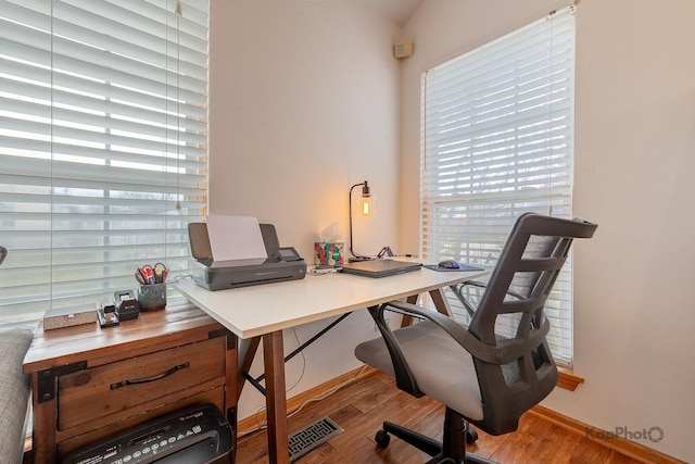 office area with wood finished floors, baseboards, and visible vents