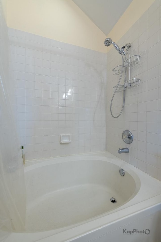 full bathroom with shower / bath combo with shower curtain and vaulted ceiling