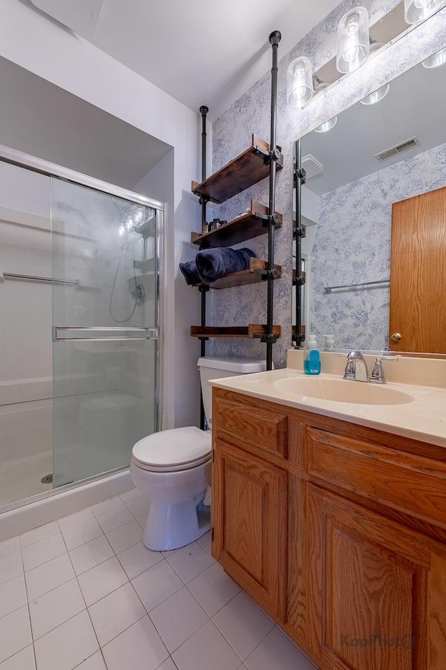 full bathroom featuring visible vents, toilet, vanity, tile patterned floors, and a stall shower