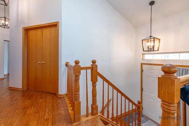 entrance foyer featuring wood finished floors, an inviting chandelier, and high vaulted ceiling