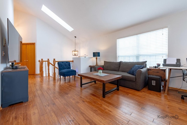 living room featuring a skylight, high vaulted ceiling, and hardwood / wood-style flooring