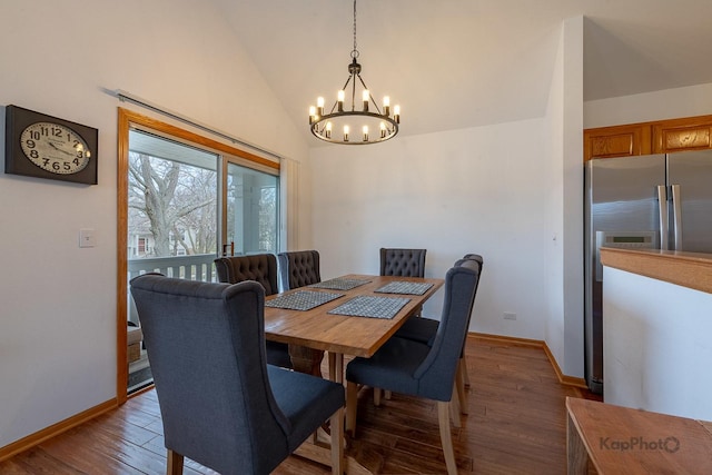 dining room with wood finished floors, a notable chandelier, lofted ceiling, and baseboards
