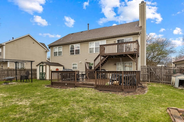 rear view of property with a chimney, a fenced backyard, a shed, and a wooden deck